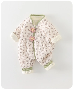 Détail d'une barboteuse matelassée pour bébé avec motif floral et bord en velours