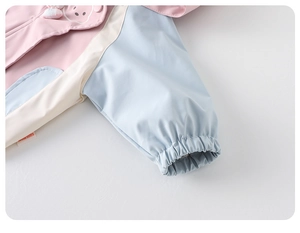 Detalle de chaqueta color-block para niña con puños elásticos y detalles de orejas