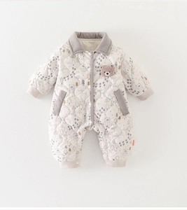 Macro detail of quilted baby romper featuring bear patterns and corduroy collar trim