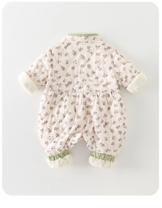 Détail de la barboteuse matelassée fleurie pour bébé avec coutures en losange et bords verts