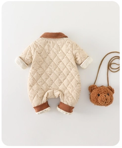 Detail of quilted beige baby romper with brown corduroy trim and cute bear print