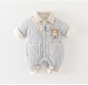 Détail de la barboteuse matelassée pour bébé avec broderie ours et nœud bleu