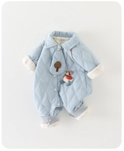 Close-up of baby romper with light blue diamond quilting and cute duck embroidery detail