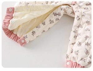 Détail de barboteuse matelassée pour bébé avec boutons-pression et motif floral rose