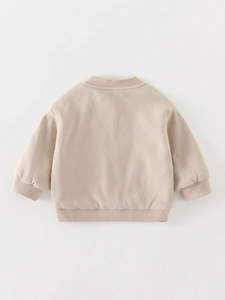 Kids minimalist beige knit sweater with waffle texture and ribbed cuffs back view
