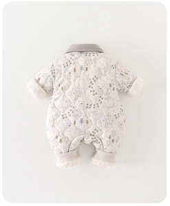 Detailed view of quilted baby romper with Nordic forest animal and pine tree patterns