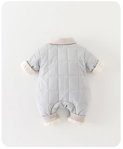 Détail de la barboteuse matelassée bleu clair pour bébé avec bordure côtelée beige douce
