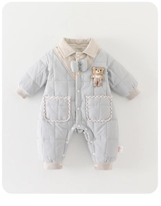 Détail d'une grenouillère matelassée bleue avec ourson 3D et bords-côtes