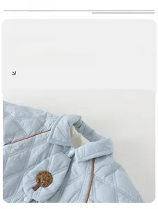 Detail of baby quilted jacket featuring diamond pattern, tree embroidery, and plush lining
