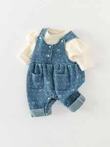 Cute infant girl two-piece outfit with white ruffled top and blue polka dot denim overalls