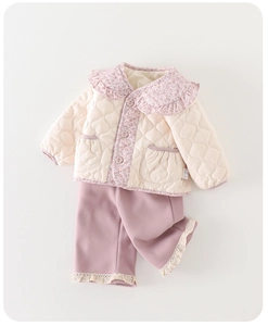 Détail veste matelassée cœur bébé fille avec col fleuri et pantalon rose bordé de dentelle