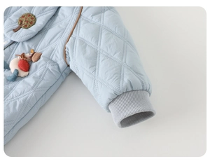 Detail of light blue quilted baby romper showing diamond texture and ribbed cuffs