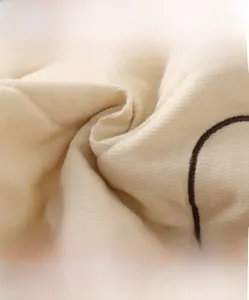 Macro shot of high-density cream corduroy fabric texture for winter boys jackets