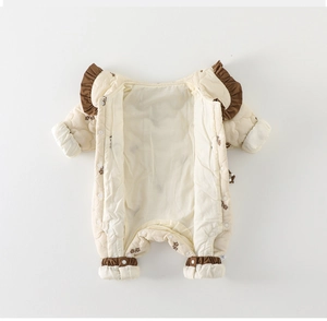 Détail d'une barboteuse matelassée pour bébé avec volants marrons et fleurs