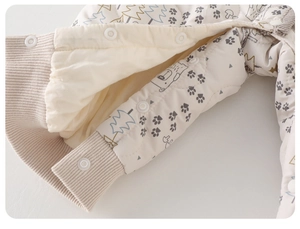 Detailed macro view of baby romper featuring soft quilted fabric and snap buttons
