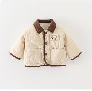 Detailed macro shot of heart-shaped quilting and contrast corduroy trim on a baby jacket