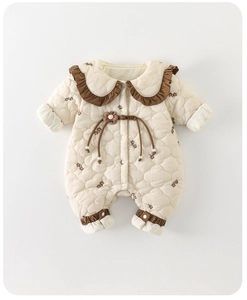 Détail d'une grenouillère matelassée pour bébé avec broderie nuage et col en dentelle