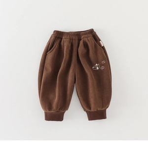Detail view of brown corduroy baby pants with airplane embroidery and ribbed cuffs