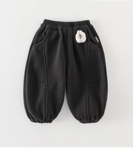 Vue détaillée du pantalon de jogging noir pour enfant avec écusson pomme blanche