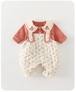 Detail of floral baby romper featuring Peter Pan collar with delicate flower embroidery