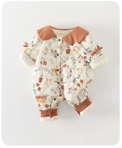 Detalle de pelele acolchado para bebé con estampado floral y cuello de pana marrón