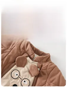 Detail of baby quilted vest with cute bear embroidery and 3D ear design in brown color