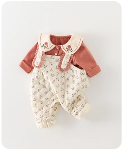 Close-up of baby winter romper set with cherry embroidered collar and floral quilted texture