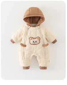 Detail of baby quilted romper featuring double zippers and cute bear patch design