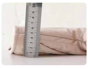 Thickness measurement of the pink padded winter jacket using a steel ruler showing 7-8cm depth