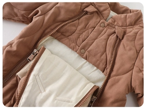 Close-up of quilted warm baby romper with double-closure zipper and snap buttons