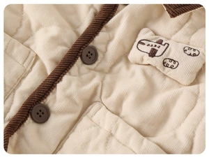 Macro detail of corduroy quilted jacket with brown buttons and small plane patch