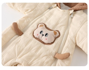Detail showing the quilted diamond texture and 3D cartoon bear patch on baby romper