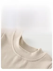 Détail du col montant beige sur ce pull en maille thermique douce pour nourrissons