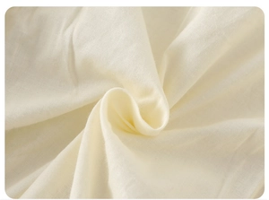 Gros plan du tissu du barboteuse bébé montrant la texture coton lin couleur crème