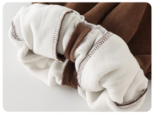 Close-up of brown ribbed knit fabric with thick white fleece lining for winter jacket