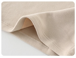 Gros plan sur la texture polaire douce et les coutures de ce haut thermique pour enfant