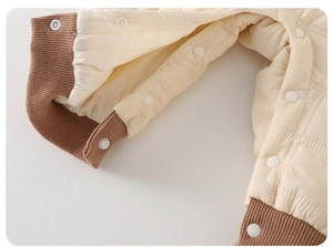 Close-up of baby winter jumpsuit featuring quilted fabric and secure snap buttons