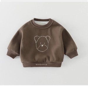 Close-up of brown kids' sweatshirt featuring a white bear print and ribbed cuffs
