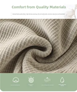 Gros plan détaillé du tissu en maille côtelée beige montrant la texture douce et dense