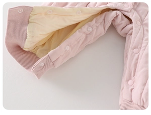 Close-up of baby romper showing quilted warm fabric and snap button closure detail