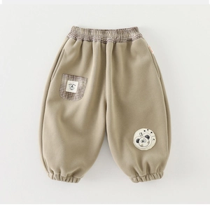 Detail of light brown girls' warm trousers with plaid elastic waist and panda patch