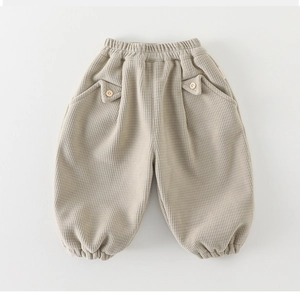 Détail du pantalon en maille gaufrée pour bébé avec taille élastique et boutons en bois