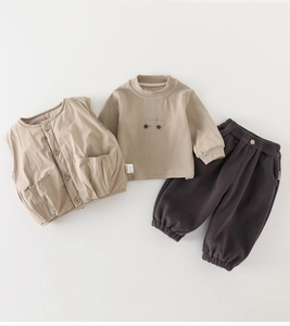 Flat lay of baby winter 3-piece set with khaki vest, brown tee, and cozy pants