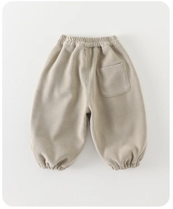 Détail de la texture gaufre beige et de la taille élastique d'un pantalon d'hiver bébé