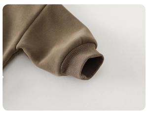 Close-up of thick brown sweatshirt fabric showing ribbed cuffs and soft fleece lining