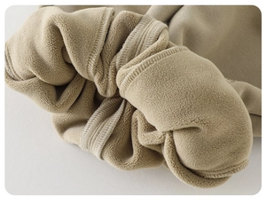 Macro shot of warm khaki fleece lining and thick knit fabric for winter kids pants