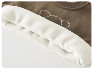 Close-up of brown kid sweatshirt with thick white fleece lining and bear embroidery