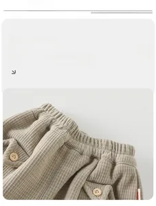 Détail du pantalon gaufré pour bébé avec taille élastique et boutons en bois déco