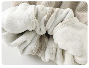 Détail du tissu gaufré beige avec doublure épaisse en laine sherpa blanche pour bébé