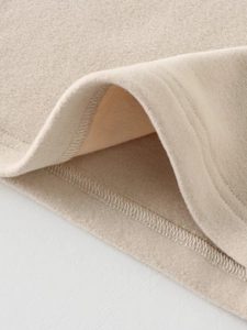 Gros plan d'un maillot de corps thermique beige montrant des coutures et un tissu polaire